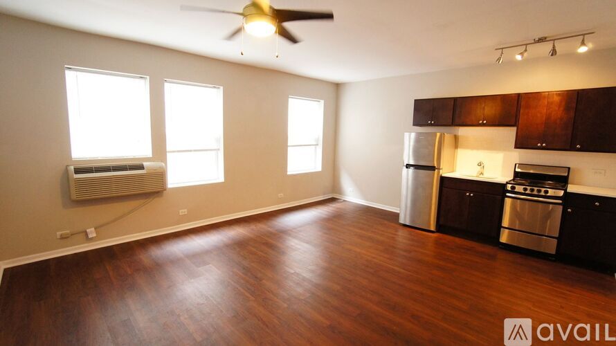 A room with wooden floors and a stainless steel dishwasher.