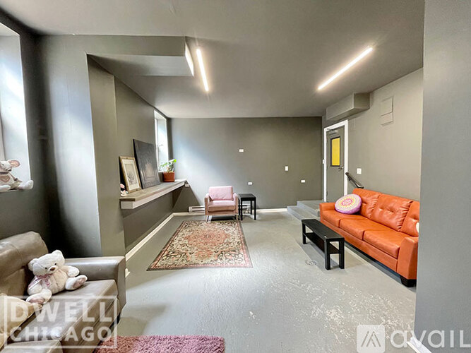 A living room with a couch, a chair, and a teddy bear.