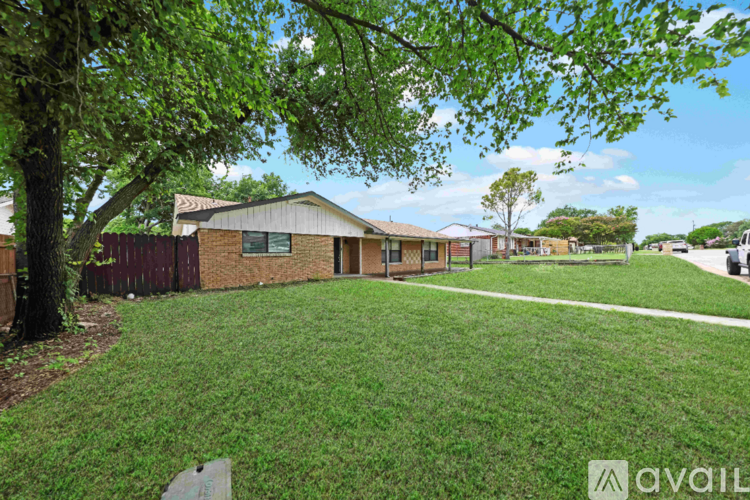 A house with a green lawn and a tree in front of it.