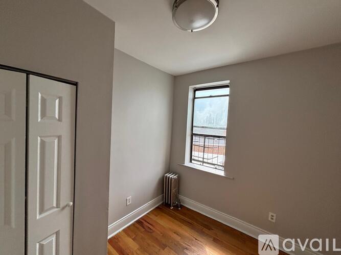 A room with a window and a radiator on the floor.