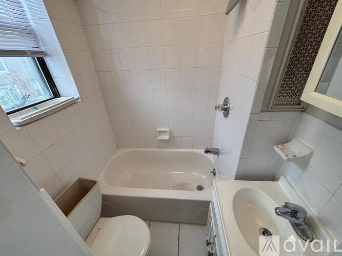 A bathroom with a tub, toilet, and sink.