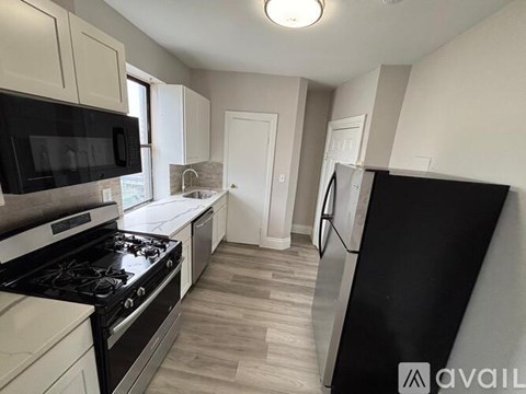 A kitchen with black appliances and white cabinets.