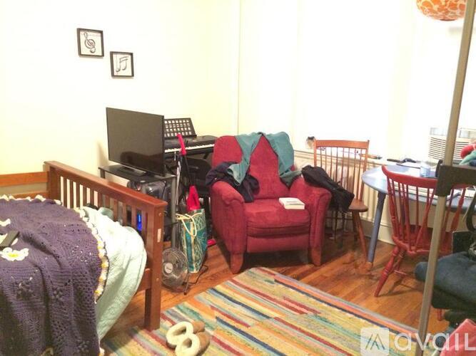 A room with a red chair and a baby crib.