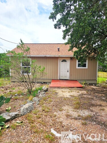 A small house with a red mat in front of it.