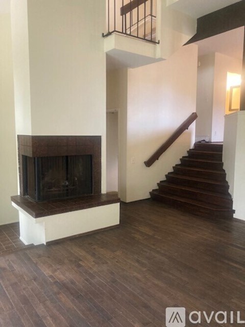 A living room with a fireplace and stairs.