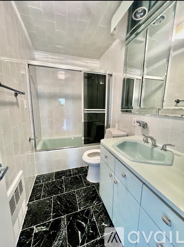 A bathroom with a sink, toilet, and a walk-in shower.