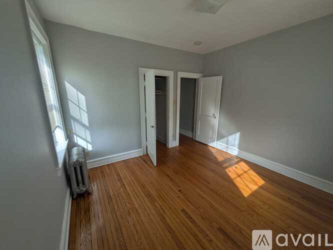 A room with wooden floors and two doors.