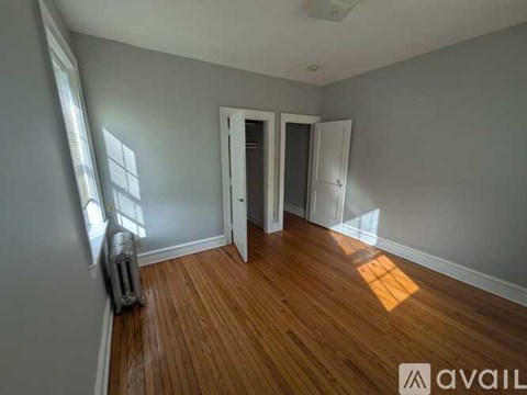 A room with wooden floors and two doors.