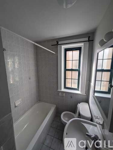 A bathroom with a tub, toilet and sink.
