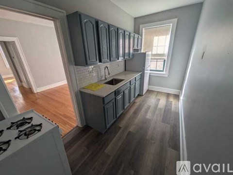 A kitchen with dark wood cabinets and a white stove top oven.