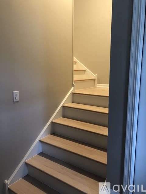 A staircase with wooden steps and a blue wall on the side.