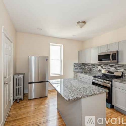 A kitchen with a granite countertop and stainless steel appliances.