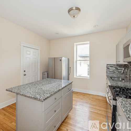 A kitchen with granite countertops and wooden floors.