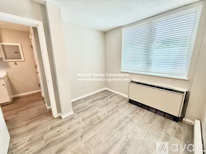 A room with a window and a radiator on the wall.