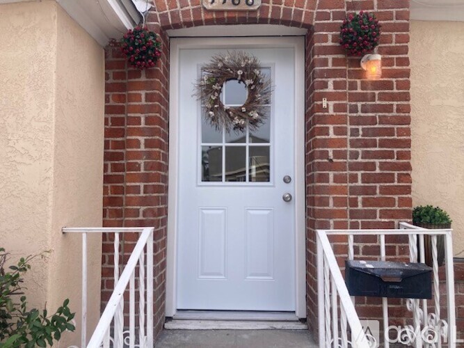 A white door with a wreath on it is the main focus of the image.