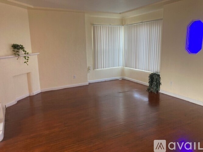 A room with wooden floors and a white fireplace.