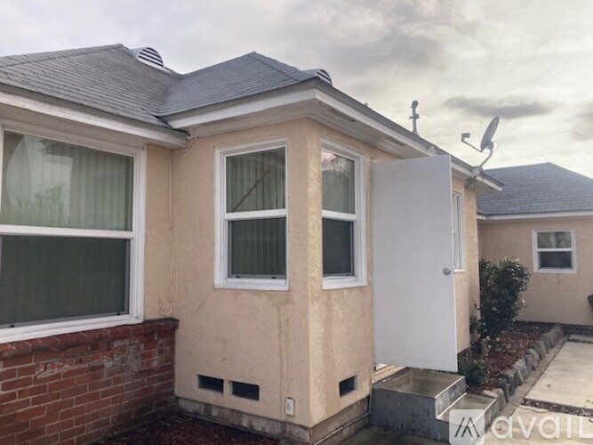 A beige house with a white door and windows.