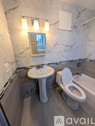 A bathroom with a marble wall and a toilet.
