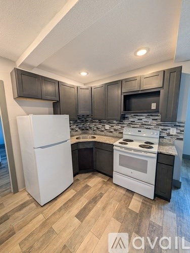 A kitchen with a white refrigerator and a white stove top oven.