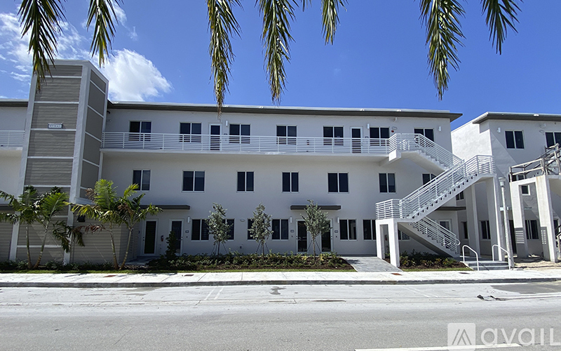 A white building with a staircase leading to the second floor.