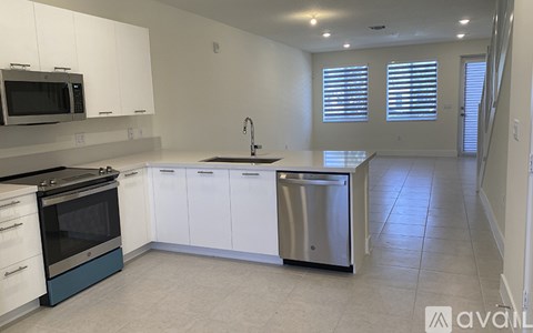 A kitchen with white cabinets and a stainless steel dishwasher.