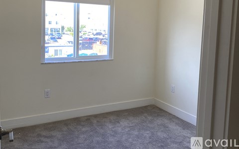 A room with a window overlooking a parking lot.