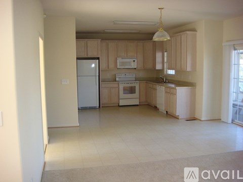 A kitchen with wooden cabinets and white appliances.
