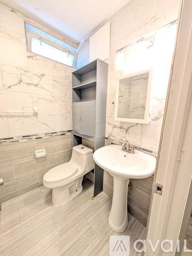 A bathroom with a toilet, sink, and a mirror.
