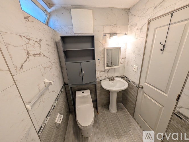A bathroom with a toilet, sink, and a mirror.