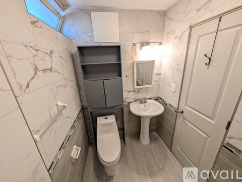 A bathroom with a toilet, sink, and a mirror.