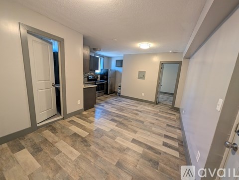 A hallway with a tiled floor and a door on the left.