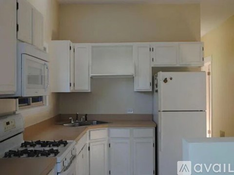 A kitchen with white cabinets and appliances.