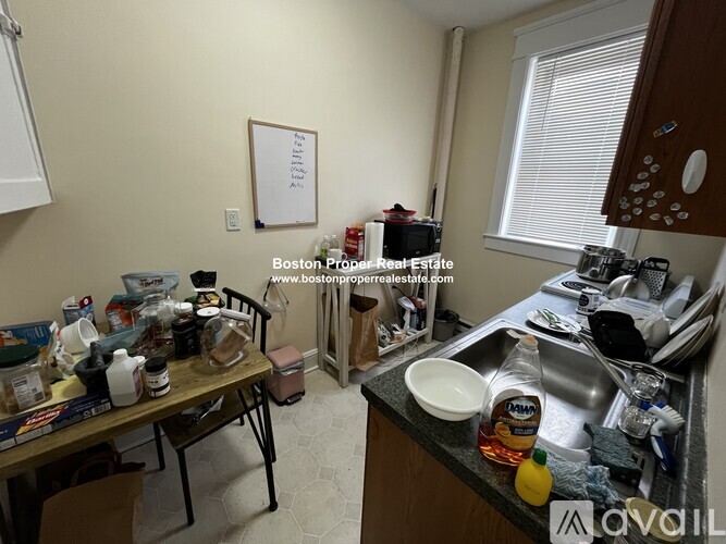 A kitchen with a table full of dishes and a whiteboard on the wall.