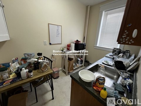 A kitchen with a table full of dishes and a whiteboard on the wall.