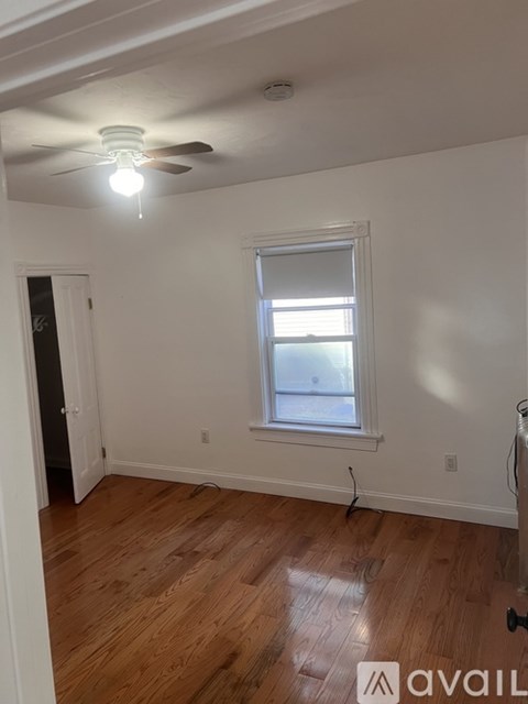 A room with a ceiling fan and a window.
