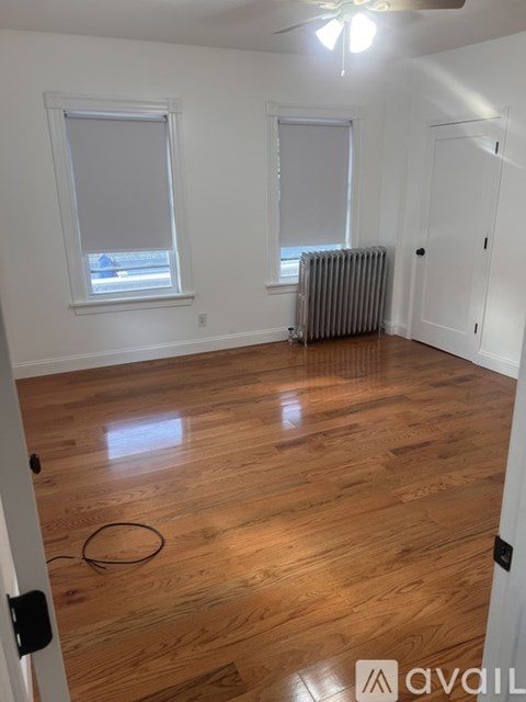 A room with wooden floors and a ceiling fan.
