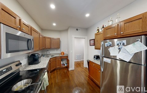 A kitchen with wooden cabinets and a stainless steel refrigerator.