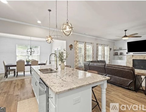 A kitchen with a marble countertop and a dining table with chairs.