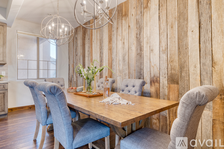 A dining room with a wooden table and chairs.