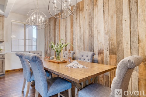 A dining room with a wooden table and chairs.