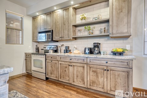 A kitchen with wooden cabinets and a marble countertop.