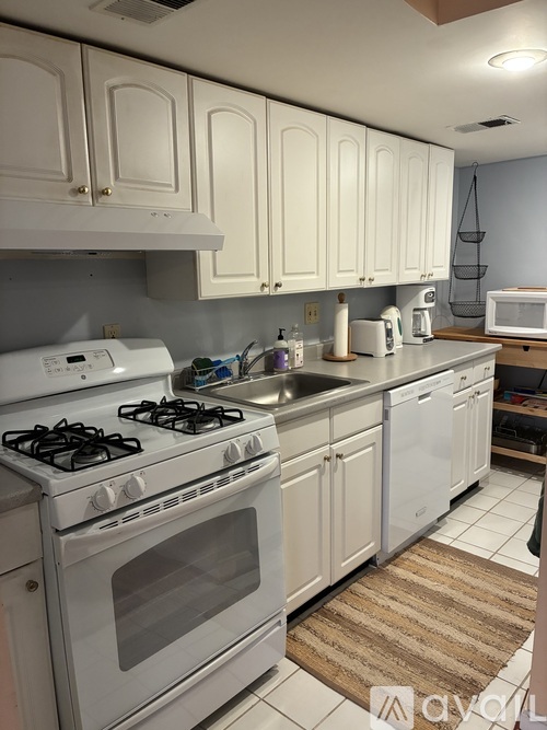 A kitchen with white cabinets and appliances.