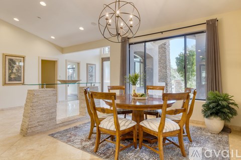 A dining room with a wooden table and chairs.