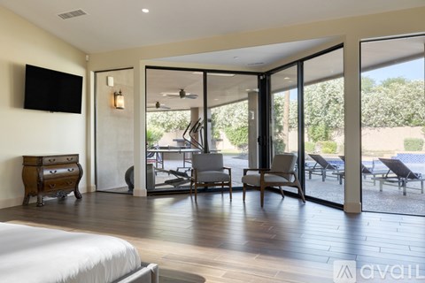 A bedroom with a large bed and a television on the wall.