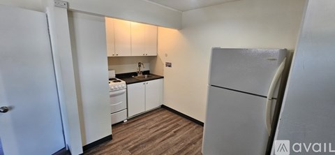 A kitchen with white cabinets and a white fridge.