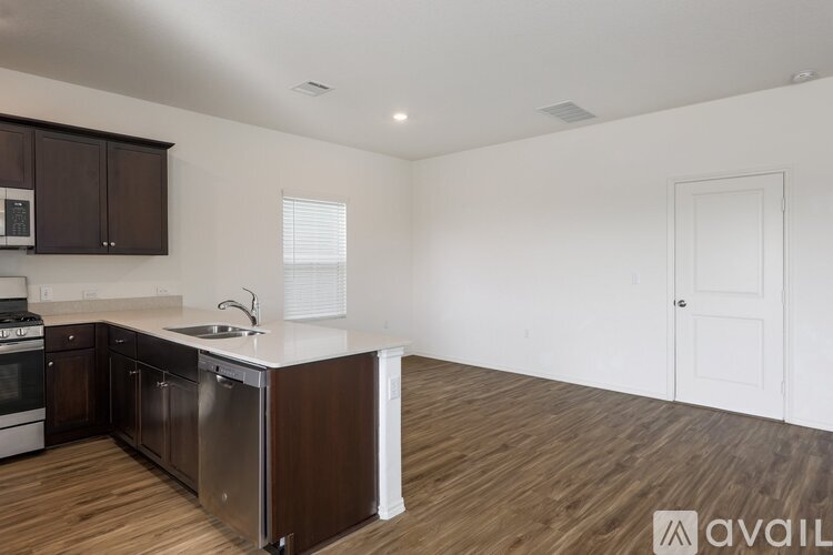 A kitchen with dark brown cabinets and a white countertop.