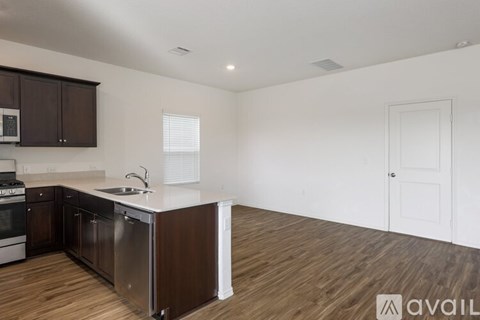 A kitchen with dark brown cabinets and a white countertop.