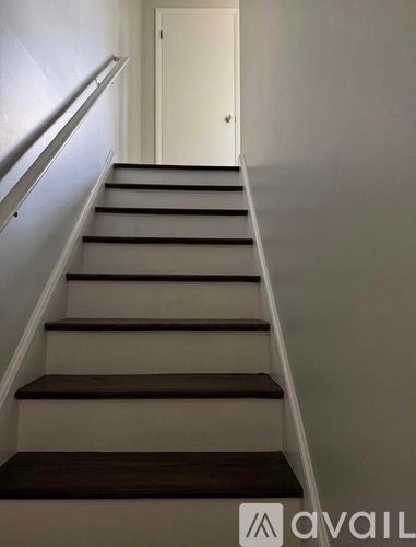 A staircase with a white door at the top.