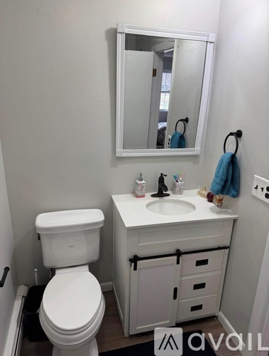 A white toilet sits next to a sink in a small bathroom.