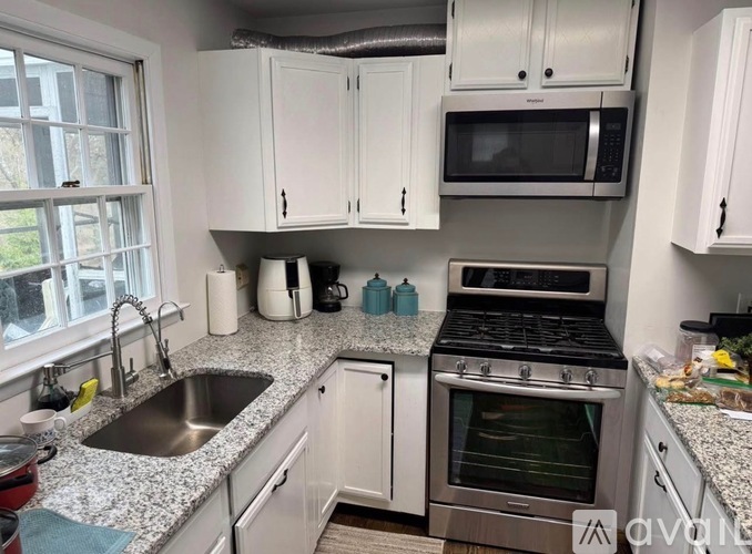A kitchen with white cabinets and a stainless steel oven.